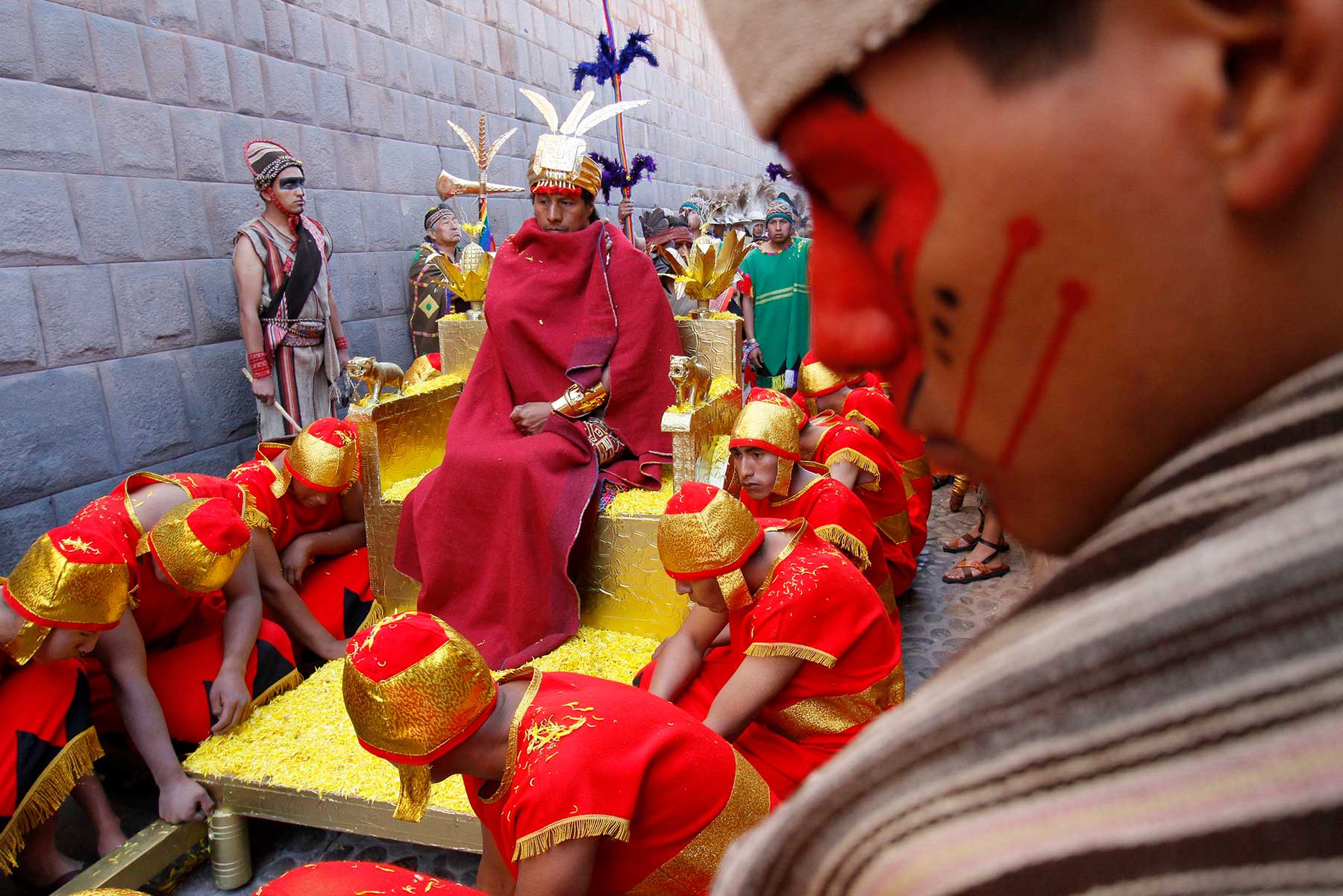 Los súbditos hacen un alto en el traslado del inca por algunas calles de la ciudad del Cusco, que está de fiesta.
